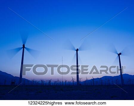 Silhouette of wind turbines in a field with a mountain range in the distance at sunset; Palm Springs, California, United States of America View Large Photo Image Stock Photograph - Silhouette of wind turbines in a field with a mountain range in the distance at sunset; Palm Springs, California, United States of America. Fotosearch