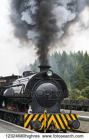 Smoke billows from the engine of a train; North Yorkshire, England View Large Photo Image Stock Photograph - Smoke billows from the engine of a train; North Yorkshire, England. Fotosearch