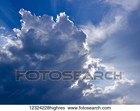 Stock Photograph - Sunlight illuminating clouds; Alberta, Canada. Fotosearch