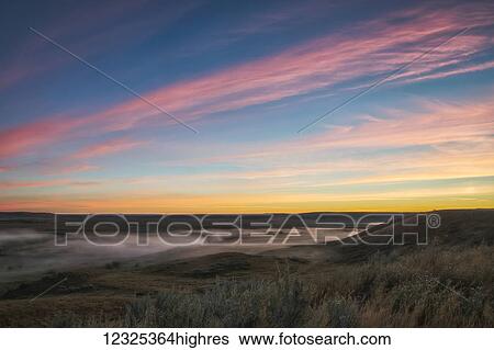 Stock Photograph - Sunrise colour over the Frenchman River Valley in Grasslands National Park; Saskatchewan, Canada. Fotosearch