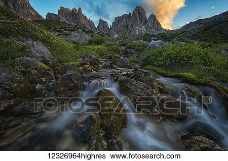 Stock Photograph - Sunrise over a beautiful mountain stream in the Dolomite mountains of Italy; Cortina, Italy. Fotosearch