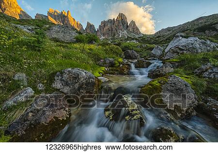 Stock Photograph - Sunrise over a mountain stream in the Italian Dolomites; Cortina, Italy. Fotosearch