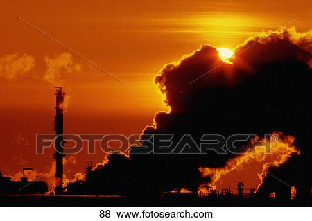 Stock Photo - Sunset behind factory steam. Fotosearch