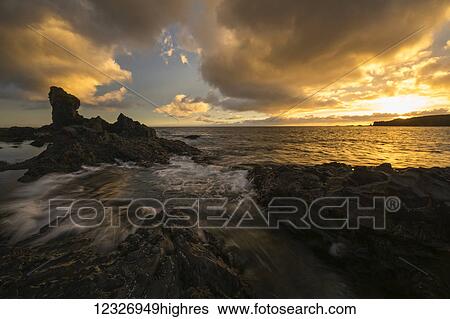 Stock Photograph - Sunset over the beach called Djupalonsandur which on the western tip of the Snaefellsness Peninsula; Iceland. Fotosearch