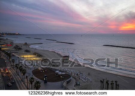 Stock Photograph - Sunset over the Mediterranean and a road along the beachfront; Tel Aviv, Israel. Fotosearch