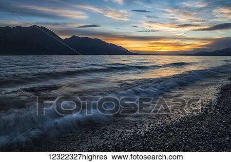 Stock Photograph - Surf along the shore of Kluane Lake at sunset; Yukon, Canada. Fotosearch