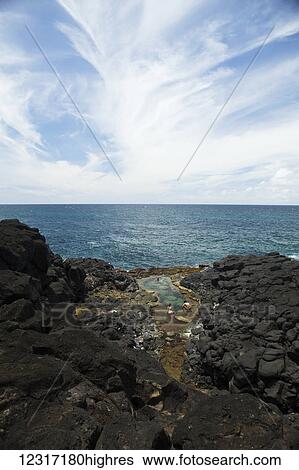 Stock Photograph - Swimmers in tide pools, Queens Bath; Princeville, Kauai, Hawaii, United States of America. Fotosearch