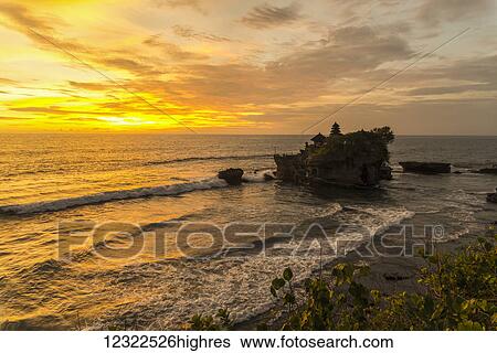 Stock Photograph - Tanah Lot temple with a golden sunset; Bali Island, Indonesia. Fotosearch
