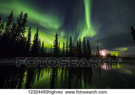Stock Photograph - The aurora and rising moon reflect in the Clearwater River in Delta Junction; Alaska, United States of America. Fotosearch