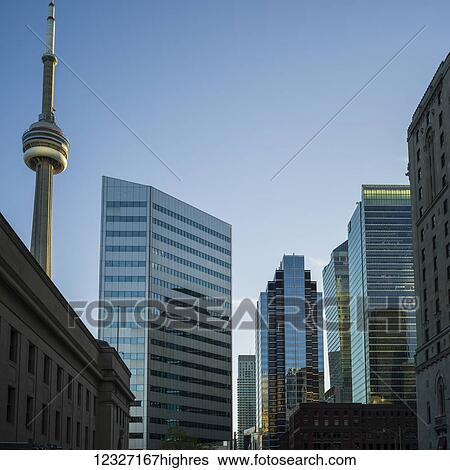 The CN Tower and a view of numerous skyscrapers with a variety of architectural styles against a blue sky; Toronto, Ontario, Canada View Large Photo Image Stock Photograph - The CN Tower and a view of numerous skyscrapers with a variety of architectural styles against a blue sky; Toronto, Ontario, Canada. Fotosearch