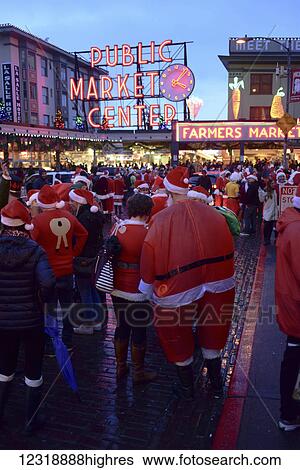 Stock Photograph - The Drunk santas Christmas party, a traditional annual gathering of hundreds of jolly Christmas revelers bar hopping through downtown Seattle including making a stop at the world famous Pike Place Public Market; Seattle, Washington, United States. Fotosearch