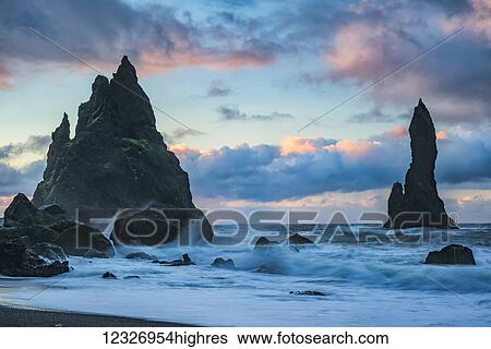 The sea stacks known as Reynisdrangar with waves and sunrise happening above them, South Coast; Iceland View Large Photo Image Stock Photograph - The sea stacks known as Reynisdrangar with waves and sunrise happening above them, South Coast; Iceland. Fotosearch