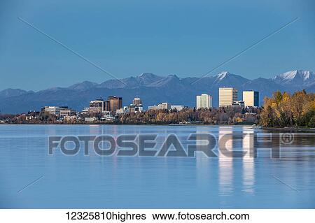 The setting sun reflects off of office buildings in downtown Anchorage, seen from Earthquake Park, the Chugach Mountains in the background, South-central Alaska; Anchorage, Alaska, United States of America View Large Photo Image Stock Photograph - The setting sun reflects off of office buildings in downtown Anchorage, seen from Earthquake Park, the Chugach Mountains in the background, South-central Alaska; Anchorage, Alaska, United States of America. Fotosearch