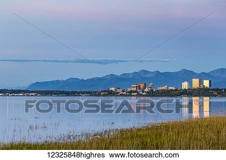The setting sun reflects off of office buildings in downtown Anchorage, seen from Earthquake Park, golden grass along the shoreline in the foreground, the Chugach Mountains in the background, South-central Alaska; Anchorage, Alaska, United States of... View Large Photo Image Stock Photograph - The setting sun reflects off of office buildings in downtown Anchorage, seen from Earthquake Park, golden grass along the shoreline in the foreground, the Chugach Mountains in the background, South-central Alaska; Anchorage, Alaska, United States of.... Fotosearch