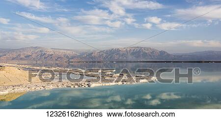 Stock Photograph - The sky and mountains of the Judean Desert reflected in the tranquil water of the Dead Sea; South District, Israel. Fotosearch