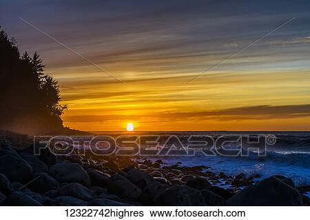 Stock Photograph - The sun sets over the ocean on the Oregon Coast; Seaside, Oregon, United States of America. Fotosearch