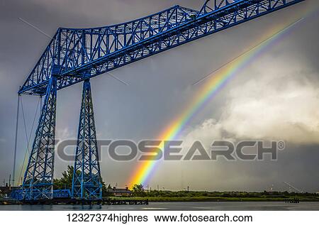 The Tees Transporter Bridge was built between 1910 and 1911 and carries a traveling 'gondola', suspended from the bridge, across the River Tees in 90 seconds. The gondola can carry 200 people, 9 cars, or 6 cars and one minibus; Middlesbrough, North... View Large Photo Image Stock Photograph - The Tees Transporter Bridge was built between 1910 and 1911 and carries a traveling 'gondola', suspended from the bridge, across the River Tees in 90 seconds. The gondola can carry 200 people, 9 cars, or 6 cars and one minibus; Middlesbrough, North.... Fotosearch