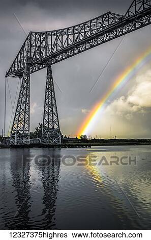 Stock Photograph - The Tees Transporter Bridge was built between 1910 and 1911 and carries a traveling 'gondola', suspended from the bridge, across the River Tees in 90 seconds. The gondola can carry 200 people, 9 cars, or 6 cars and one minibus; Middlesbrough, North.... Fotosearch