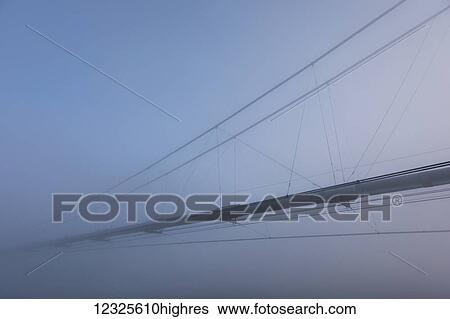 Stock Photograph - The Trans-Alaska Pipeline appears through fog where it crosses the Tanana River on a subzero morning; Alaska, United States of America. Fotosearch