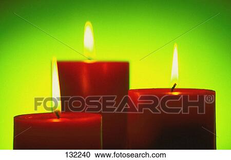 Stock Image - Three lit candles. Fotosearch