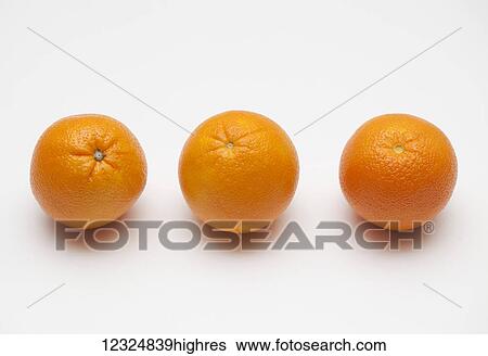 Stock Photograph - Three oranges on a white background; Ontario, Canada. Fotosearch