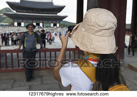 Stock Photograph - Tourist photographs a0ther tourist at Gyeongbokgung Palace; Seoul, Korea. Fotosearch
