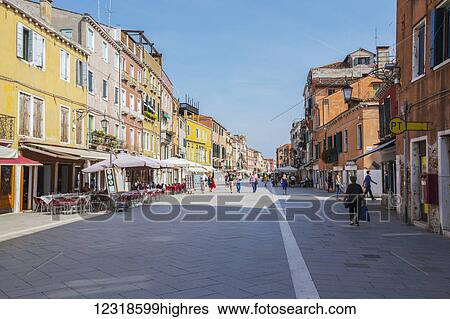 Tourists and locals explore one of the less busy streets in Venice at the far end of the city where there are many restaurants and shops but less people; Venice, Italy View Large Photo Image Stock Photograph - Tourists and locals explore one of the less busy streets in Venice at the far end of the city where there are many restaurants and shops but less people; Venice, Italy. Fotosearch