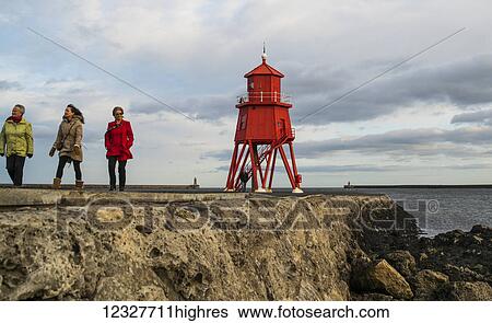 Tourists walking on a pier and Herd Groyne Lighthouse; South Shields, Tyne and Wear, England View Large Photo Image Stock Photograph - Tourists walking on a pier and Herd Groyne Lighthouse; South Shields, Tyne and Wear, England. Fotosearch
