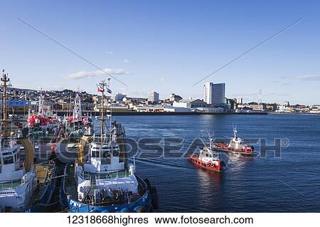 Stock Photograph - Tugs head out from pier; Punta Arenas, Magallanes and Antartica Chilena, Chile. Fotosearch