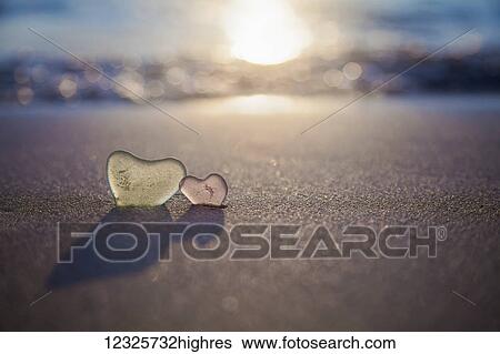 Two glass hearts in the sand on the beach at the water's edge; Honolulu, Oahu, Hawaii, United States of America View Large Photo Image Stock Photograph - Two glass hearts in the sand on the beach at the water's edge; Honolulu, Oahu, Hawaii, United States of America. Fotosearch