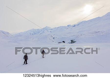 Two snowshoers approach Canwell Glacier in the Alaska Range on a winter day; Alaska, United States of America View Large Photo Image Stock Photograph - Two snowshoers approach Canwell Glacier in the Alaska Range on a winter day; Alaska, United States of America. Fotosearch