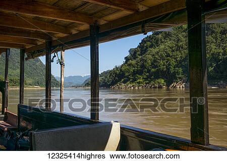 Stock Photograph - View of a river from the window of a tour boat; Luang Prabang Province, Laos. Fotosearch