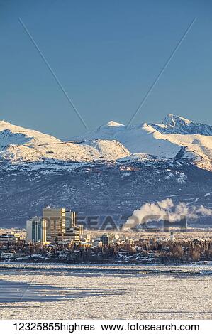 View of downtown Anchorage in winter and the snow-capped Chugach Mountains beyond seen from Point MacKenzie, the skies in the background clear and bright, sea ice covering Cook Inlet in the foreground, South-central Alaska; Anchorage, Alaska, United... View Large Photo Image Stock Photograph - View of downtown Anchorage in winter and the snow-capped Chugach Mountains beyond seen from Point MacKenzie, the skies in the background clear and bright, sea ice covering Cook Inlet in the foreground, South-central Alaska; Anchorage, Alaska, United.... Fotosearch