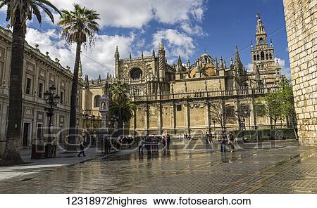 Stock Photograph - View of Seville Cathedral and Archivio de Indias from Real Alcazar entrance; Seville, Andalusia, Spain. Fotosearch