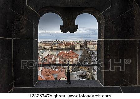 Stock Photograph - View of the city of Prague framed through a uniquely shaped window; Prague, Czechia. Fotosearch