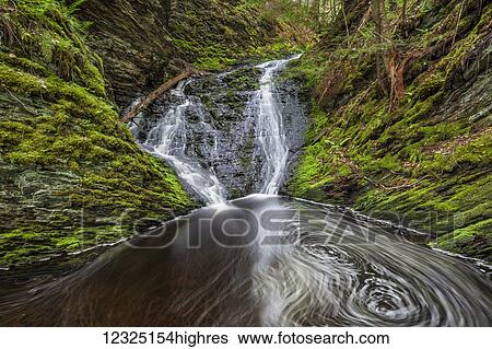 Stock Photograph - Waterfall and pool in a mossy forest ravine in springtime along Old Sanford Brook near West Gore; Nova Scotia, Canada. Fotosearch