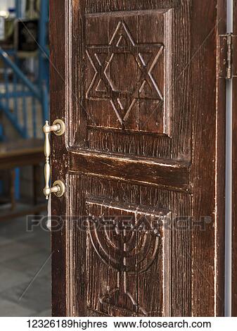 Stock Photograph - Wooden door carved with the Star of David and Menorah at one of the city's historic synagogues, Beit Knesset Abuhav; Safed, Galilee, Israel. Fotosearch