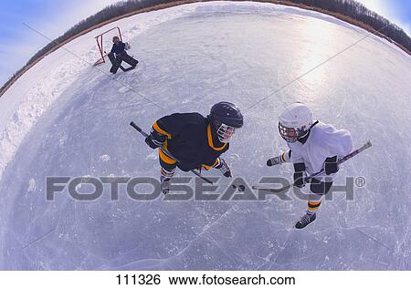 Young boys playing ice hockey outdoors View Large Photo Image Stock Photograph - Young boys playing ice hockey outdoors. Fotosearch