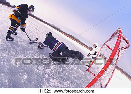 Young boys playing ice hockey outdoors View Large Photo Image Stock Photography - Young boys playing ice hockey outdoors. Fotosearch