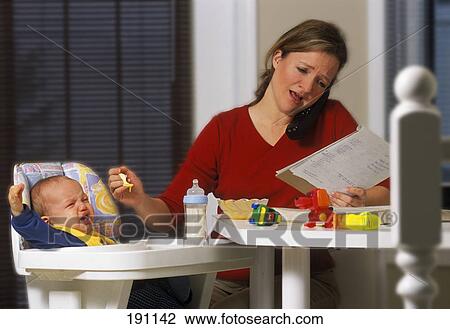 Stock Image - Young mother working from home. Fotosearch