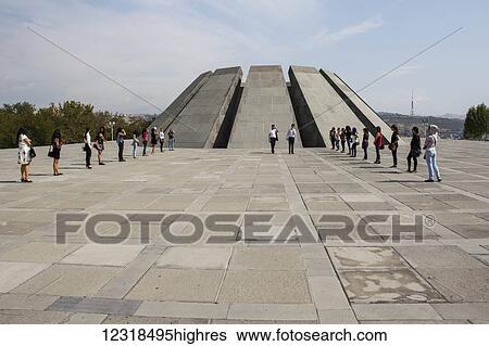 Stock Photograph - Young people in front of the twelve slabs positioned in a circle, representing the twelve lost provinces in present-day Turkey at the Armenian Ge0cide memorial complex on Tsitsernakaberd hill; Yerevan, Armenia. Fotosearch