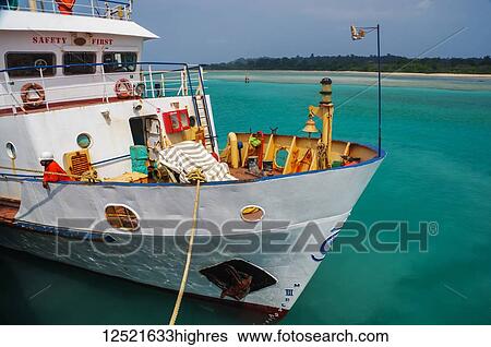 Stock Photograph - A boat mooring in the turquoise waters; Andaman Islands, India. Fotosearch