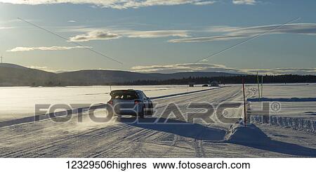 A Car Drives Over A Snow-Covered Road Under A Blue Sky With Cloud And Mountains In The Distance; Arjeplog, Norrbotten County, Sweden View Large Photo Image Stock Photograph - A Car Drives Over A Snow-Covered Road Under A Blue Sky With Cloud And Mountains In The Distance; Arjeplog, Norrbotten County, Sweden. Fotosearch