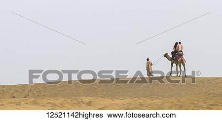 A couple on a camel safari on the Lakhmana Dunes; Damodara, Rajasthan, India View Large Photo Image Stock Photograph - A couple on a camel safari on the Lakhmana Dunes; Damodara, Rajasthan, India. Fotosearch