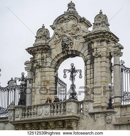 A couple stands on a balcony with an ornate archway behind them and decorative lamp posts; Budapest, Budapest, Hungary View Large Photo Image Stock Photograph - A couple stands on a balcony with an ornate archway behind them and decorative lamp posts; Budapest, Budapest, Hungary. Fotosearch