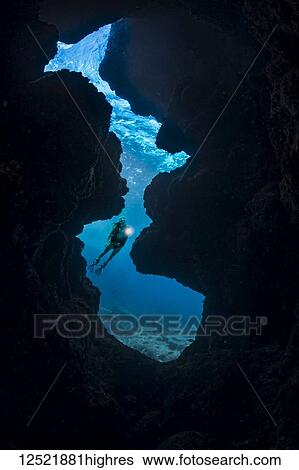 A diver (MR) shines her light into a crevice opening off Kaiwe Point on the Kona coast; Island of Hawaii, Hawaii, United States of America View Large Photo Image Stock Photograph - A diver (MR) shines her light into a crevice opening off Kaiwe Point on the Kona coast; Island of Hawaii, Hawaii, United States of America. Fotosearch
