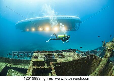 Stock Photograph - A diver swims over The Carthaginian, a Lahaina landmark, that was sunk as an artifical reef off Lahaina, Maui, Hawaii in December 2005. The Atlantis submarine visites the site several times every day; Maui, Hawaii, USA. Fotosearch