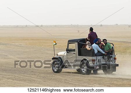 A family rides in the back of a recreational vehicle exploring the Sam sand dunes; Damodara, Rajasthan, India View Large Photo Image Stock Photograph - A family rides in the back of a recreational vehicle exploring the Sam sand dunes; Damodara, Rajasthan, India. Fotosearch