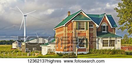 A farmhouse with a barn, silo and wind turbine behind it and cattle grazing in a field; Flesherton, Ontario, Canada View Large Photo Image Stock Photograph - A farmhouse with a barn, silo and wind turbine behind it and cattle grazing in a field; Flesherton, Ontario, Canada. Fotosearch