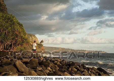 Stock Photograph - A fisherman stands fishing along the Hamakua coast, Lapahoehoe Nui Valley; Island of Hawaii, Hawaii, United States of America. Fotosearch
